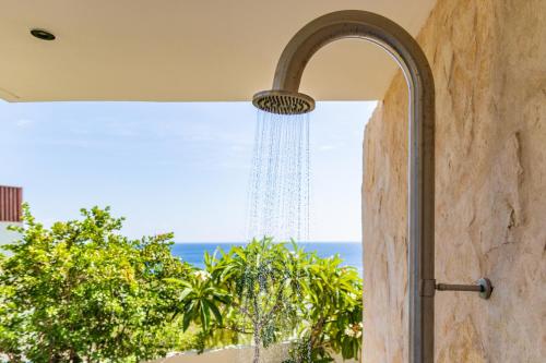 a shower in a room with a view of the ocean at Luxury 12-Guest Villa in Gated Community with Pool, Ocean View & Private Beach Access in Willibrordus