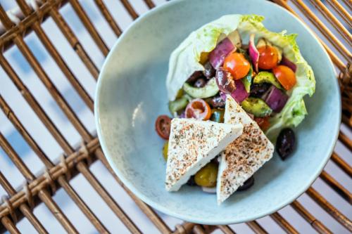 a plate of food with a salad on a table at Taj Jumeirah Lakes Towers in Dubai