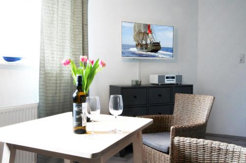 un comedor con una mesa con una botella de vino y dos copas en Bude 1: Liebevoll saniert & komfortabel, en Kiel