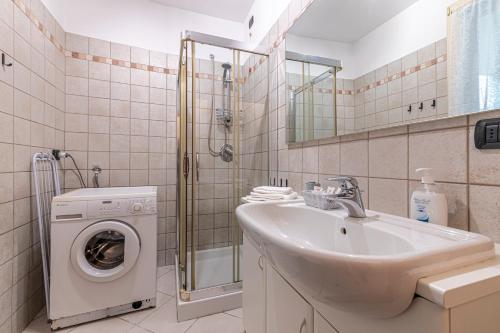 ein Badezimmer mit einem Waschbecken und einer Waschmaschine in der Unterkunft [Lago di Como] Lecco Centro - 1’ da lago/stazione in Lecco