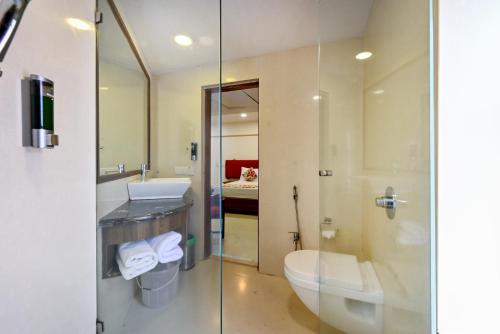 a bathroom with a toilet and a sink and a shower at Hotel Parle International in Mumbai