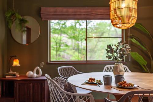 a dining room with a table and chairs and a window at S-villa Nasu 6th in Anazawa