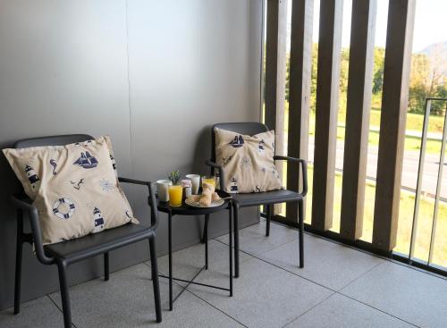 two chairs and a table with a plate of food on it at Casa Grande in Techelsberg am Worthersee