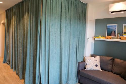 a living room with blue curtains and a couch at Casa Grande in Techelsberg am Worthersee