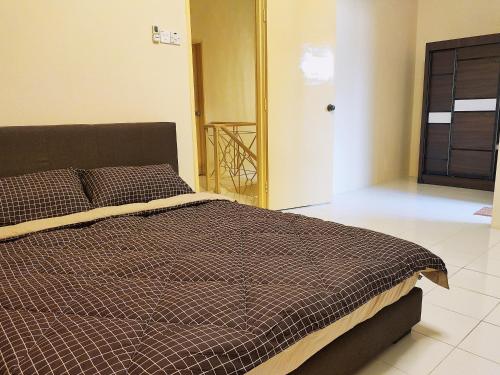 um quarto com uma cama com um edredão castanho em Kapar Nala 50 Double storey3 Rooms 1-6 pax em Kapar