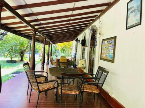 a dining room with a table and chairs on a porch at Manik Villa in Bentota