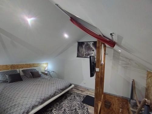 een slaapkamer met een bed en een tv aan de muur bij Gîte Sauna Balnéo Berck sur Mer Lâchez Prise in Berck-sur-Mer