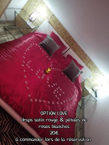 a bedroom with a red bed with pillows at Gîte Sauna Balnéo Lâchez Prise Meublé de tourisme classé 3 étoiles VERTON in Berck-sur-Mer
