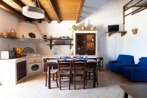 una cucina con tavolo e divano blu di Villa Alessandro a Castellammare del Golfo