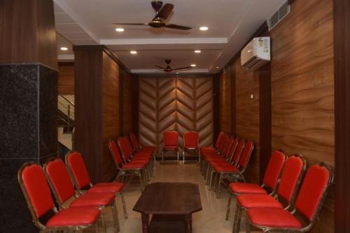 a conference room with red chairs and a wooden wall at Hotel Atlantis in Varanasi