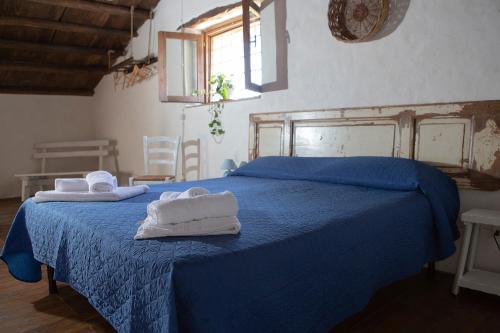 una camera da letto con un letto blu e asciugamani di Villa Alessandro a Castellammare del Golfo