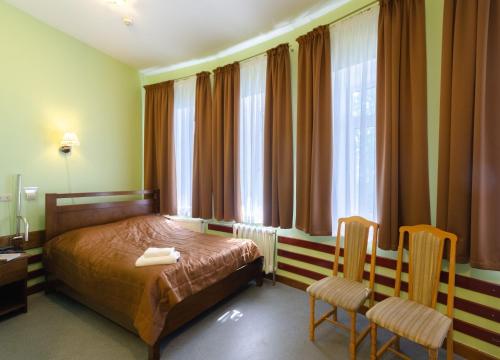 a hotel room with a bed and two chairs at Tisa Hotel in Kyiv