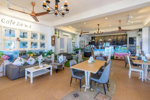 Baan Grood Arcadia Resort & Spa في بان كروت: مطعم بطاولات وكراسي ومحل