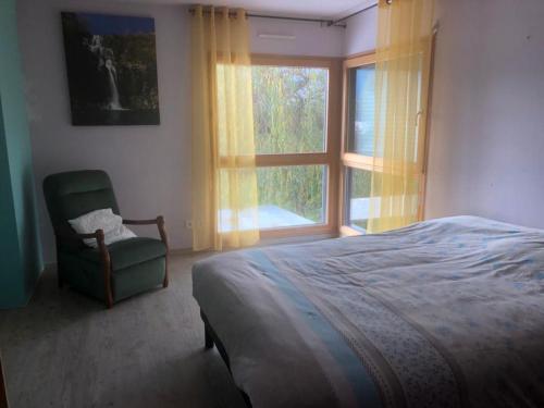 1 dormitorio con 1 cama, 1 silla y 1 ventana en villa Padivier en Saint-Point-Lac