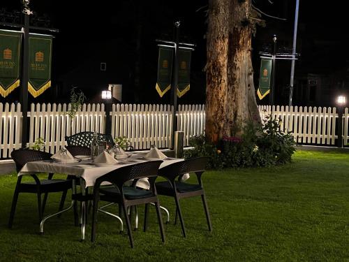 a table and chairs in a yard at night at Shaw Inn by Stay Pattern in Gulmarg