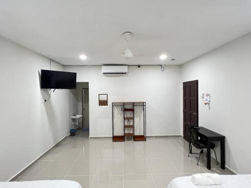 a white room with a television and a piano at TAMU ROOMSTAY TOK MOLOR in Kuala Terengganu