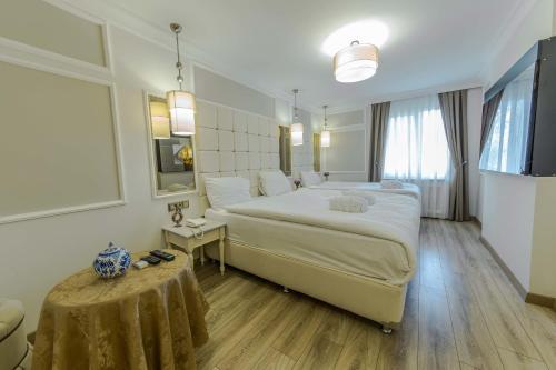 Un dormitorio con una cama grande y una mesa. en The Constantine Hotel, en Estambul