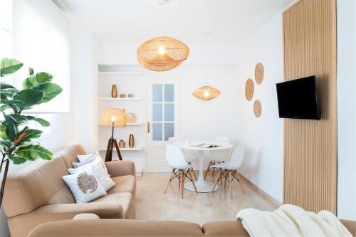 een woonkamer met een bank en een tafel bij Magno Apartments Alfarería - Private Parking included in Sevilla