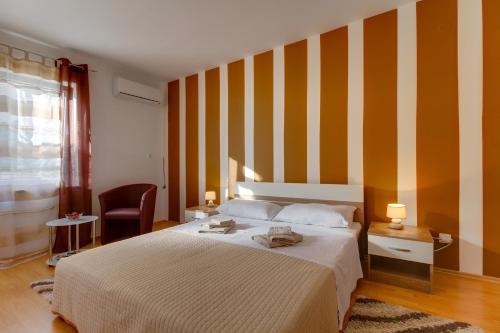 a bedroom with a bed and a striped wall at Apartment Nikolina in Mali Lošinj