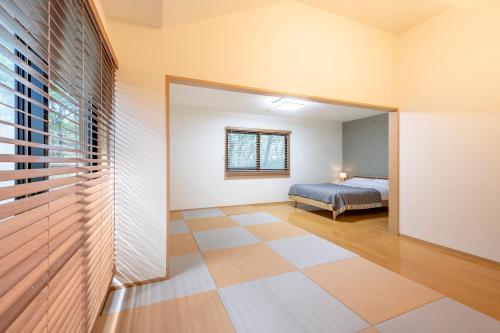 a bedroom with a bed and a large window at S-villa Nasu 9th in Nasu