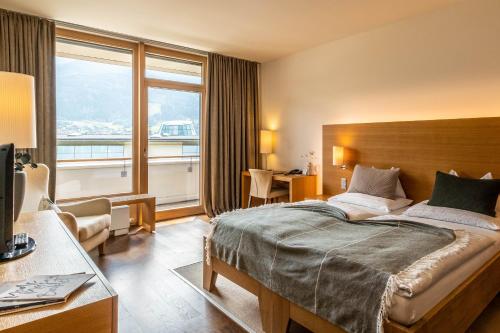 ein Hotelzimmer mit einem Bett und einem großen Fenster in der Unterkunft Tauern Spa Hotel & Therme in Kaprun
