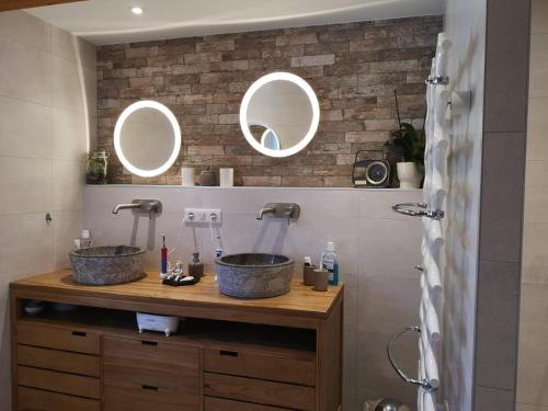two sinks in a bathroom with two mirrors at Au Verger des Louves in Helfrantzkirch