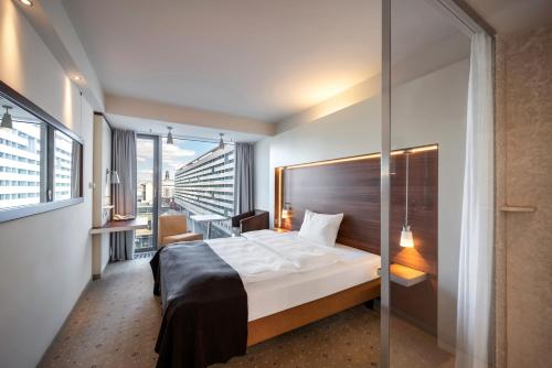 um quarto de hotel com uma cama e uma varanda em Pullman Dresden Newa em Dresden