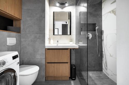 een badkamer met een toilet, een wastafel en een douche bij Apartament PRIMAVERA z miejscem parkingowym in Toruń