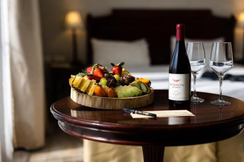 a table with a bowl of fruit and a bottle of wine at Europa 1917 in Tiberias
