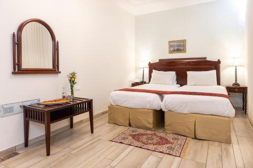a bedroom with a large bed with a table and a mirror at Europa 1917 in Tiberias