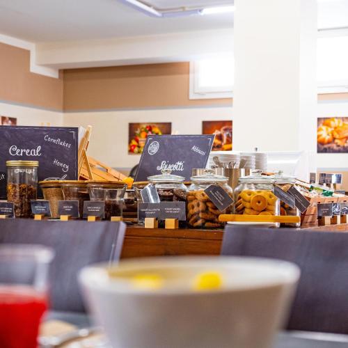 a counter with a bunch of different types of food at Park Hotel Residence in Orbetello