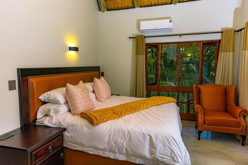 - une chambre avec un lit, une chaise et une fenêtre dans l'établissement Kruger Park Lodge Unit 268 - PMP, à Hazyview