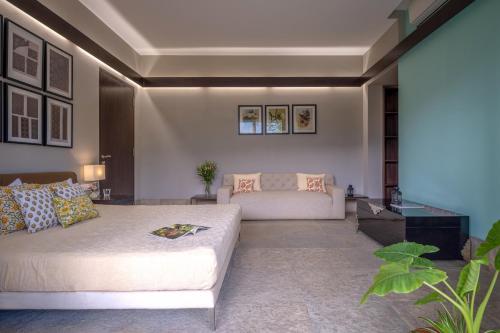 ein Wohnzimmer mit einem Bett und einem Sofa in der Unterkunft LohonoStays Villa Amber in Alibag