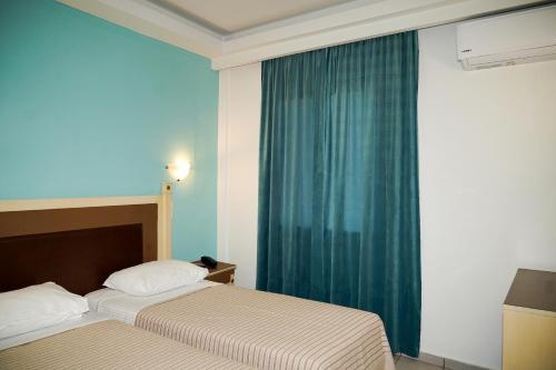 a hotel room with two beds and a window at Hotel Selini in Agrinion