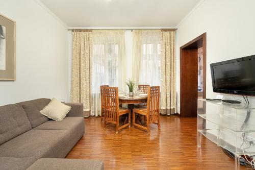 a living room with a couch and a table with chairs at Sunny Apartments in the Heart of Poznań Old Town by Renters in Poznań