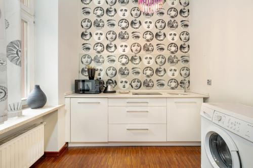 a kitchen with a wallpaper with faces on it at Sunny Apartments in the Heart of Poznań Old Town by Renters in Poznań