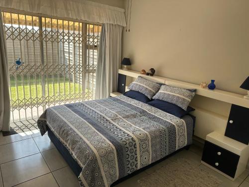 um quarto com uma cama e uma grande janela em Ipanema 2 em Margate