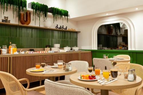 a restaurant with tables and chairs with food on them at Hotel Les Capitouls Toulouse Centre - Handwritten Collection in Toulouse