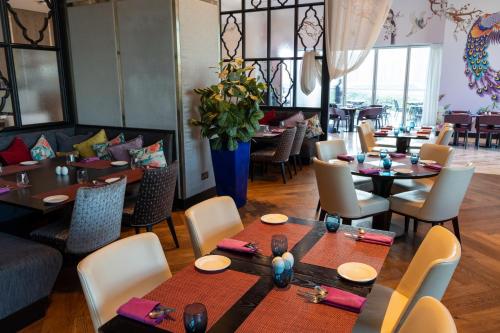 a dining room with tables and chairs in a restaurant at Taj Jumeirah Lakes Towers in Dubai