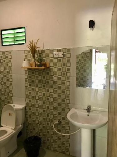 a bathroom with a sink and a toilet at Bananas Mirissa in Mirissa
