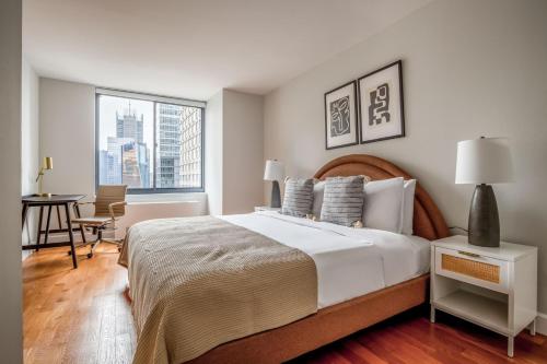een witte slaapkamer met een groot bed en een raam bij Midtown 2br w elevator wd nr entertainment NYC-1227 in New York
