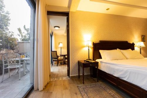 a bedroom with a bed and a balcony with a table at Europa 1917 in Tiberias