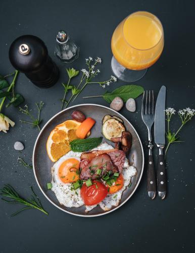 a plate of breakfast food with eggs meat and vegetables at SeeHotel Amtshof in Langenargen