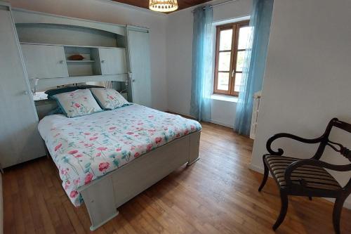 1 dormitorio con 1 cama, 1 silla y 1 ventana en Gîte pour 6 pers avec jardin clos proche Aurillac, 