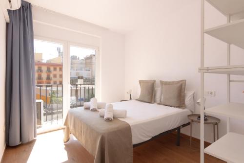 a white bedroom with a bed and a large window at Apartamento Santa Maria by Be Alicante in Alicante