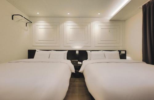 two beds are lined up in a room at Aden Hotel in Cheonan