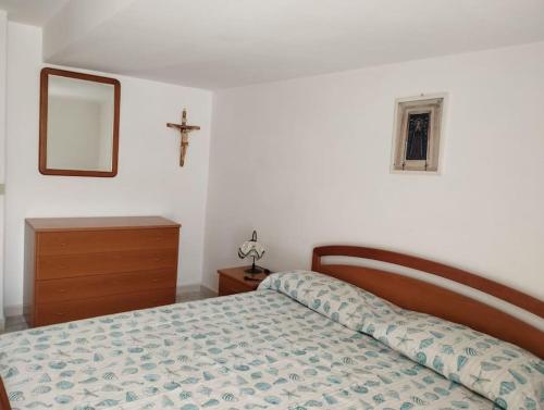 a bedroom with a bed and a cross on the wall at Casa Nannina in Ischia Town