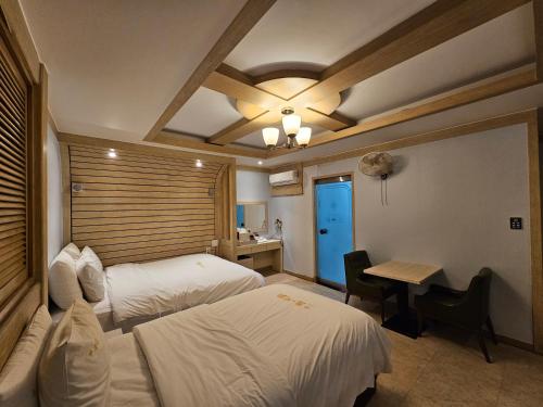 テジョンにあるHotel G7 Daejeonのベッド2台とデスクが備わるホテルルームです。