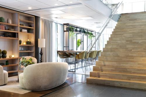 a lobby with a staircase and chairs and a table at Clarion Hotel Stavanger in Stavanger