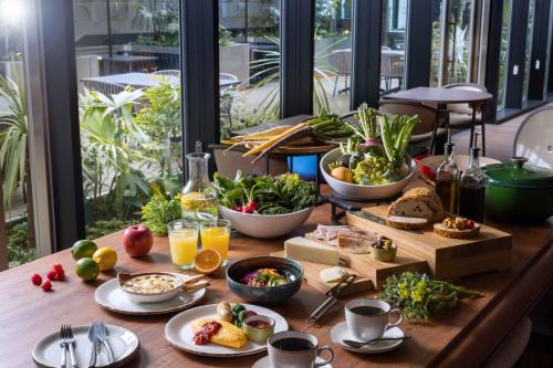 HOTEL GROOVE SHINJUKU, A PARKROYAL Hotel في طوكيو: طاولة عليها طعام ومشروبات للإفطار
